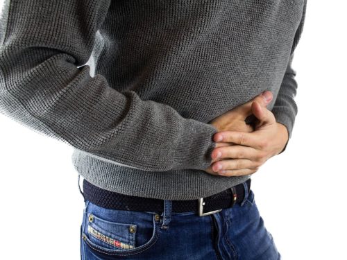 Mężczyzna trzymający się za brzuch z powodu bólu w nadbrzuszu
